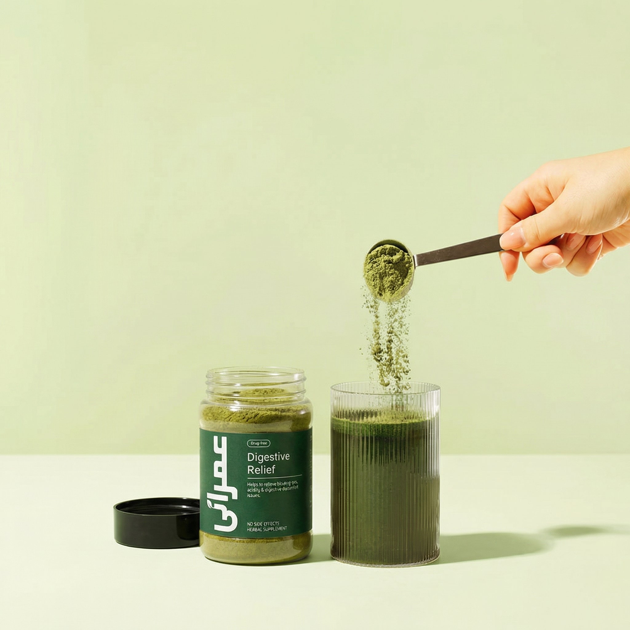 Person scooping green powder from a jar labeled 'Digestive Relief' into a glass.